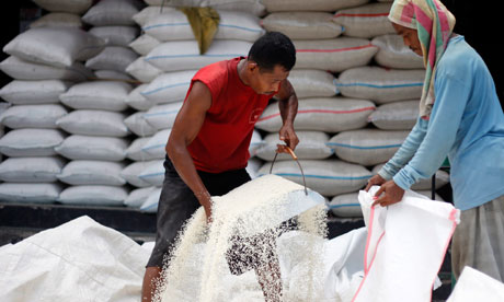 MDG: Food price : Indonesian workers load rice in to a sack at a market in Jakarta