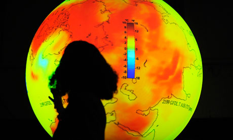 聯合國氣候會議於哥本哈根召開期間，一位科學家站在地球前面的影像。圖片節錄自：衛報報導/ Axel Schmidt/AFP/Getty Images。