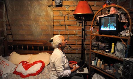MDG : Poor economics : An eldery woman plays a video game in shantytown , Colombia