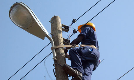 MDG : Energy and electricity policies in Liberia : An electrician works on a lamp-post 