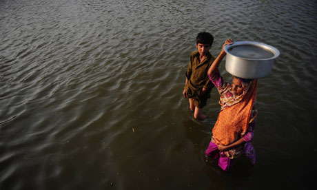MDG : Water : A Pakistani woman carries drinking water in floods water , Pakistan