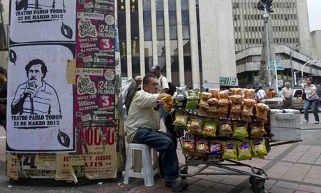 MDG : Medellin in Colombia : A peddler stays by posters with the image of drug lord Pablo Escobar