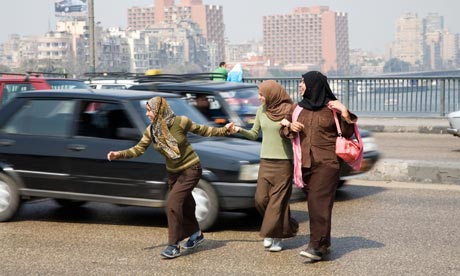MDG : Road Safety : Pedestrians cross a road durinf  heavy traffic in Cairo, Egypt