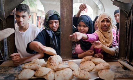 MDG : Egypt : Women buy bread from the window of a bakery in Cairo