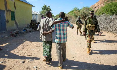 MDG : Somalia conference in London : Somali civilians walk past Ugandan soldiers from AMISOM