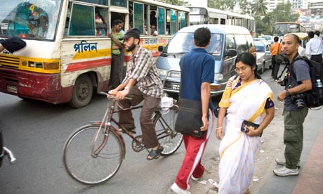 Bike blog :  A cyclist riding trought a traffic jam in a busy street of Dhaka, Bangladesh