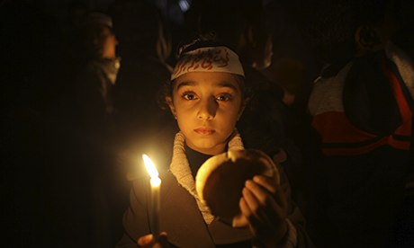 MDG : A Palestinian girl holds a candle during a vigil against the siege of Yarmouk camp, Syria