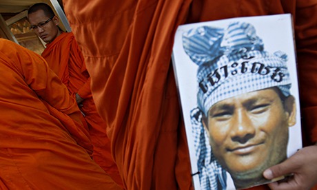 MDG : A Buddhist monk holds the portrait of a detainee during a protest in central Phnom Penh