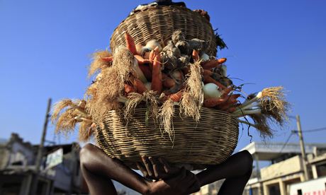 MDG: woman carries baskets of vegetables on her head