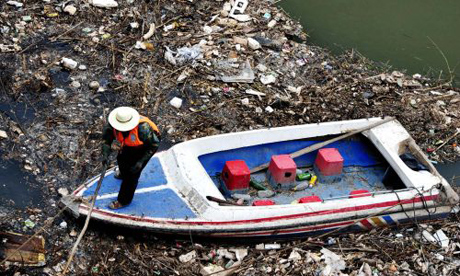 A worker clears rubbish from the Yellow river in Lanzhou in north-west China's Gansu province. Water quality along one third of China's Yellow river is now unusable because of pollution