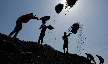 Labourers load coal on trucks at Bari Brahamina in Jammu