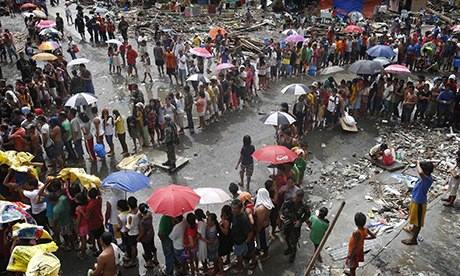 Victims of Typhoon Haiyan queue for food and water in Tacloban city