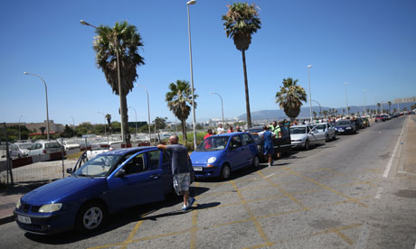 People queue with their vehicles in La Linea at the Spanish border to enter Gibraltar