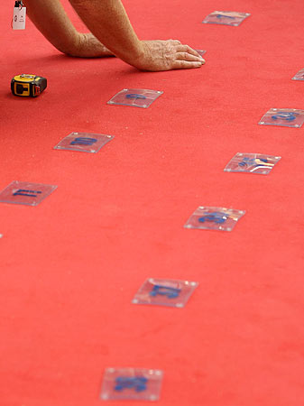 A Cannes film festival worker places numbers to mark photographers' positions