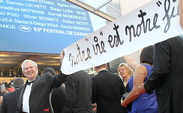 Cannes 2010 day 7: French artist Ben (left) holds a banner at Cannes film festival