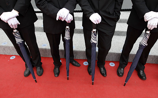 Cannes film festival day8: Cannes film festival officials with umbrellas on the red carpet