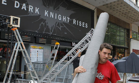 Workers dismantle an installation setup for the premiere of The Dark Knight Rises in Paris.