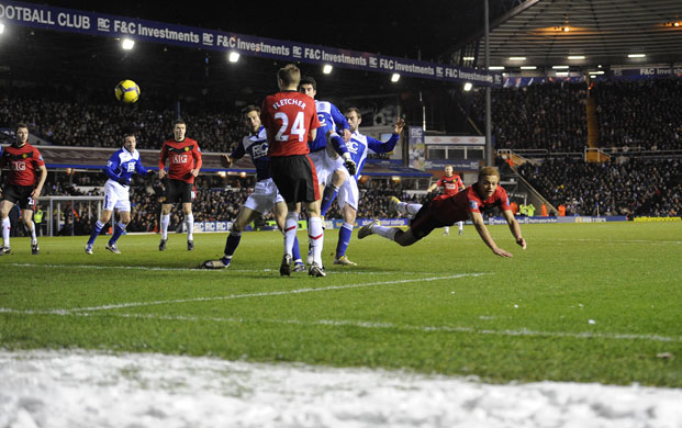 Birmingham: Snow lies just off the pitch as Wes Brown flies at a corner
