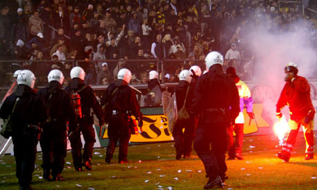 Police try to stop fans going on to the pitch during a match between AIK and Hammarby in 2004