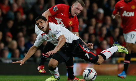 Liverpool striker Luis Suárez tumbles after a challenge by Manchester United's Phil Jones