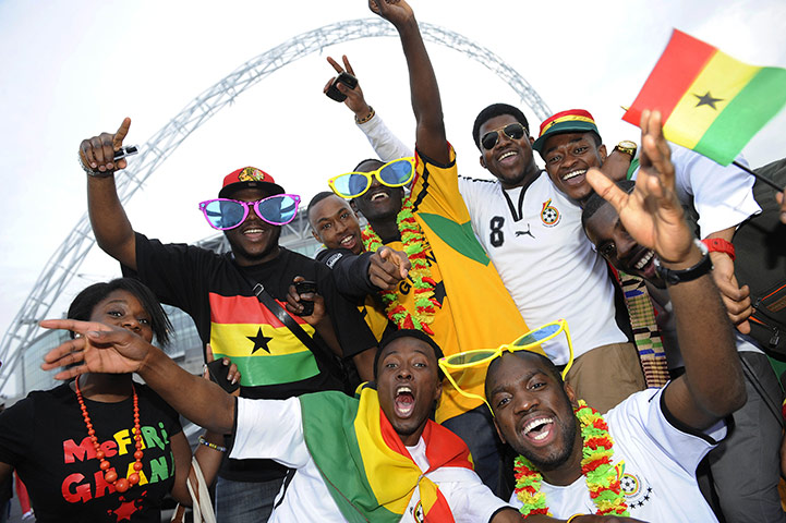 England v Ghana: Ghanaian fans pose for the camera whilst they party outside the ground