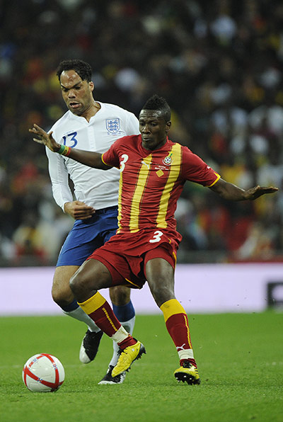 England v Ghana: Asamoah Gyan shields the ball from Joleon Lescott