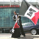 A flag vendor sets up outside Old Trafford