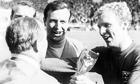 Bobby Moore passes the World Cup trophy to manager Alf Ramsey.