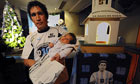 Daniel Astilleta poses with his baby Bianca after she became a member of the Maradonian Church