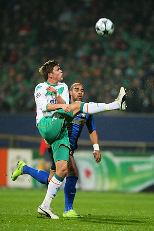 Sebastian Prodl of Bremen challenges Adriano of Milan