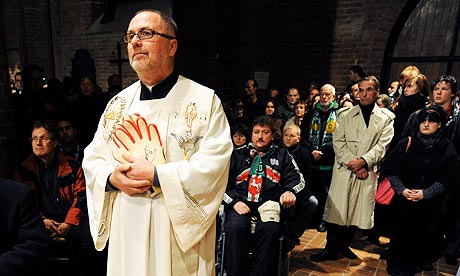 Catholic priest Heinrich Plochg holds Robert Enke's keeper's gloves