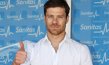 Xabi Alonso poses for photos after passing a medical at Real Madrid