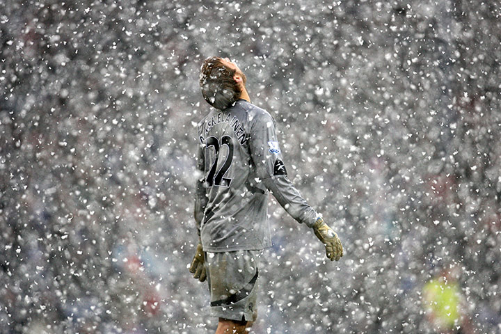 Football white-outs: Bolton goalkeeper Jussi Jaaskelainen looks to the heavens as snow falls