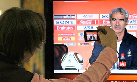 A journalist takes a picture on a TV screen of France coach Raymond Domenech