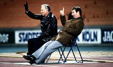 Brian Clough and Peter Taylor sit watching from the running track during Forest's second-leg win