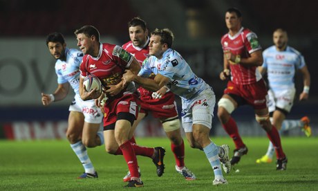 Scarlets' Rhys Priestland tries to escape from Racing's  Adrien Planté in their Heineken Cup match