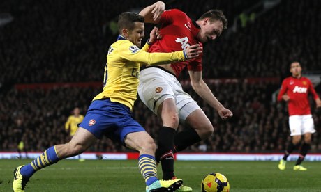 Arsenal's Wilshere challenges Manchester United's Phil Jones 
