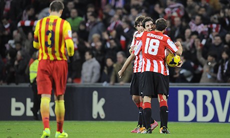 Barcelona's Gerard Pique, left, leaves the pitch as Athletic Bilbao celebrate