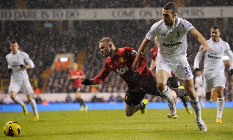 Steven Caulker of Tottenham tackles Manchester United's Wayne Rooney 