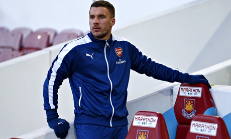 Lukas Podolski takes his seat on the bench before Arsenal's game at West Ham