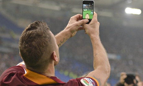 Roma's Francesco Totti celebrates taking a selfie after scoring against Lazio