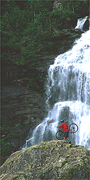 Cyclist by a waterfall