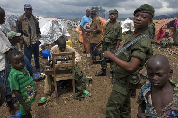 Gallery Conflict in Congo: A Government soldier talks to displaced people in a refugee camp in Kibati