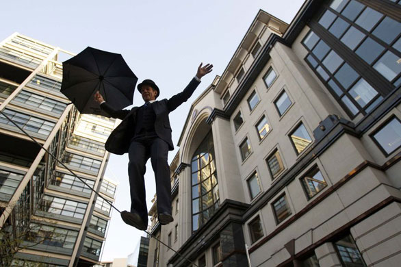 Gallery November 12 2008: London, UK: A man dressed as a city gentleman walks across a tightrope