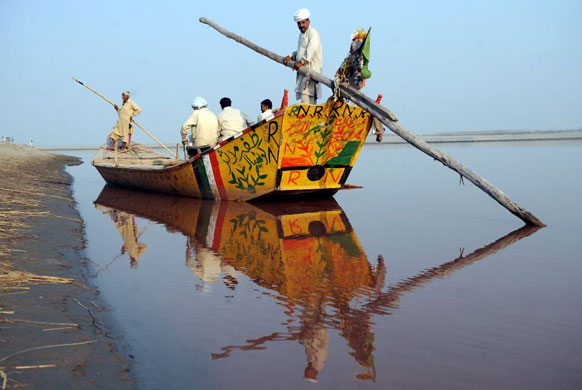 Gallery November 18 2008: Villagers wait for others on a boat before crossing the Chenab river
