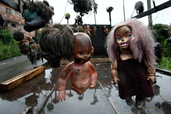 Gallery November 19 2008: Caracas, Venezuela: Parts of dolls hang on the truck of an artist