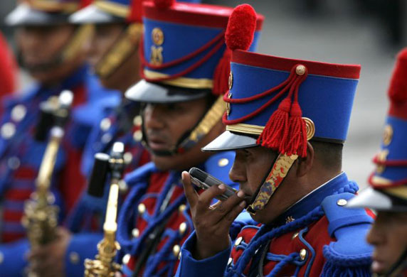 Gallery November 24 2008: Lima, Peru: An honour guard chats on his phone at the government palace