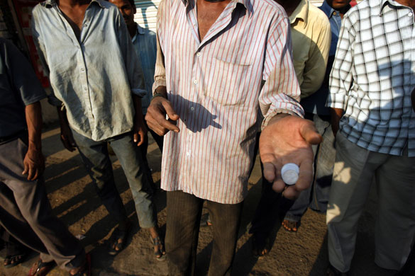 Gallery November 25 2008: Mumbai, India: A migrant worker shows the amount of money he has earned