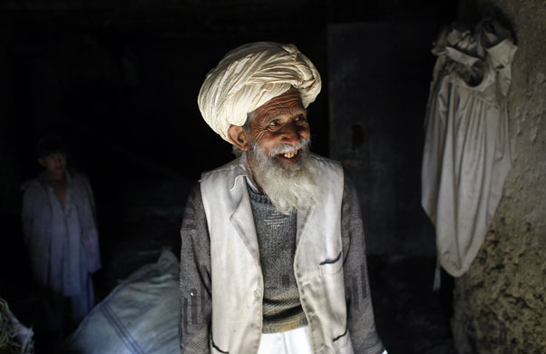 Gallery November 25 2008: Derezda Valley, Afghanistan: A man watches as US soldiers search his home