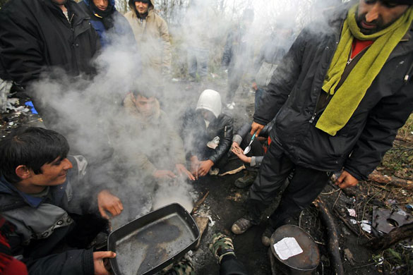 Gallery November 26 2008: Calais, France: Illegal immigrants cook meat in the woods where they camp
